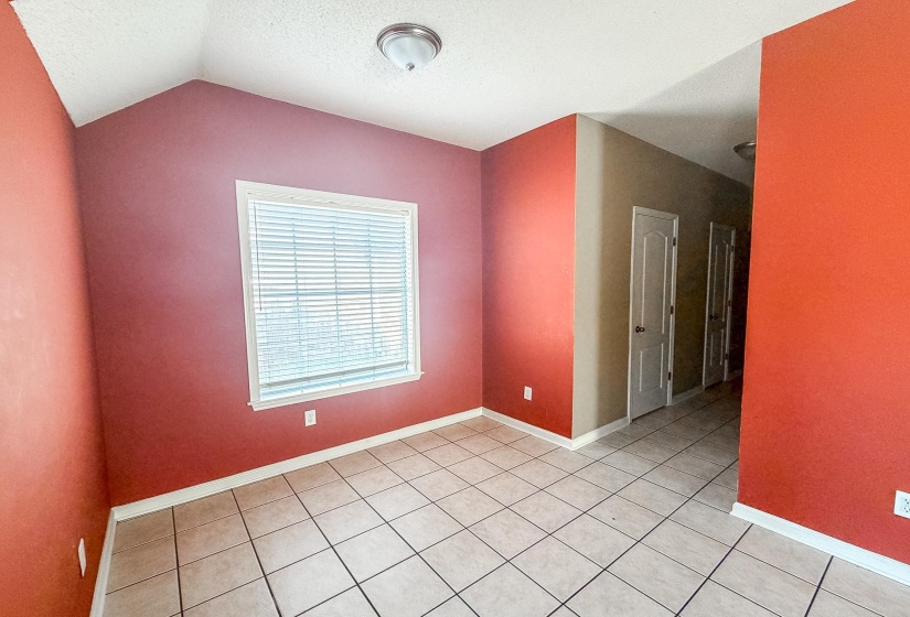 Bright interior space featuring a window with blinds, tile flooring, and a semi-flush mount ceiling light