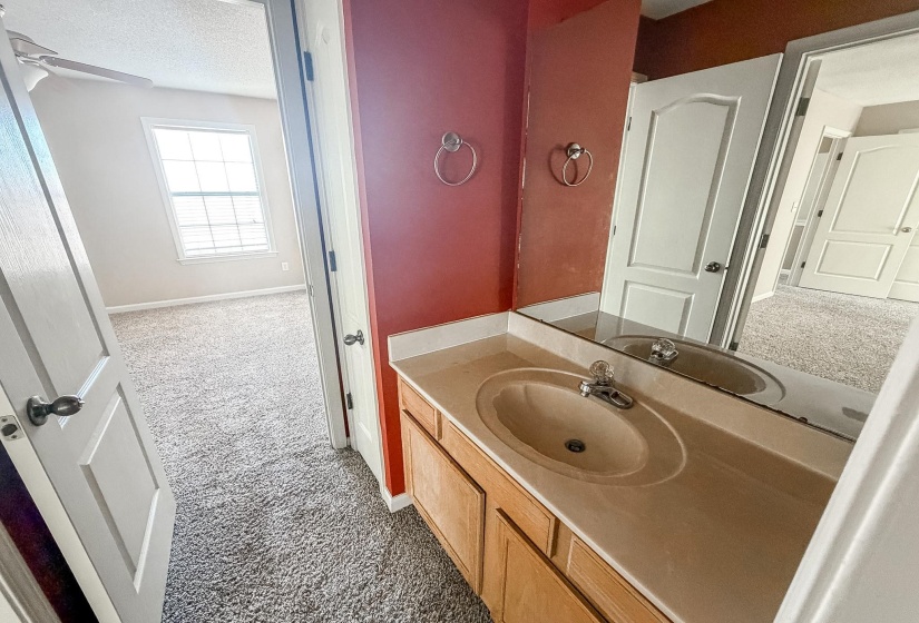 Bathroom vanity featuring a built-in sink, chrome faucet, and wood-finish cabinetry