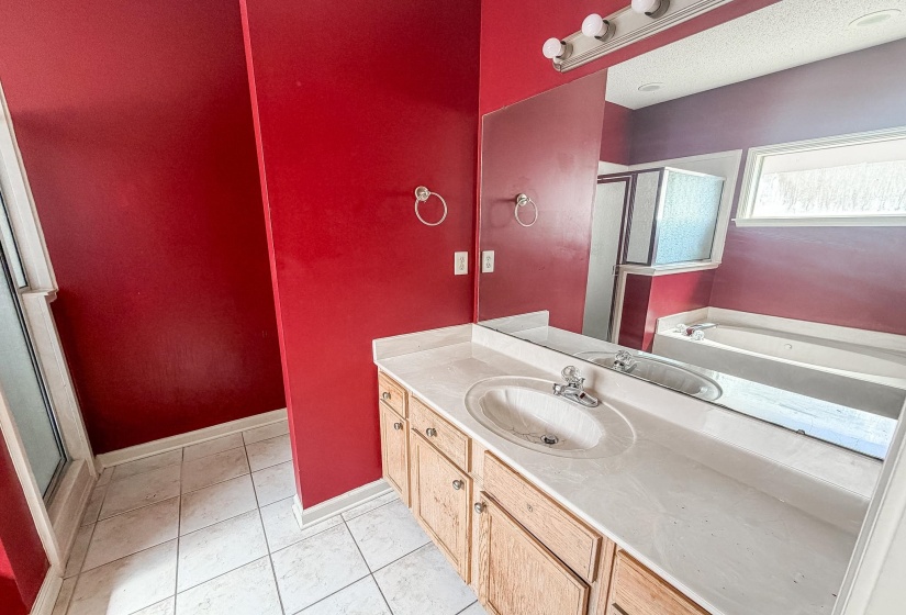 Bathroom featuring a wood-finish vanity with a single basin sink and a stone-finish countertop