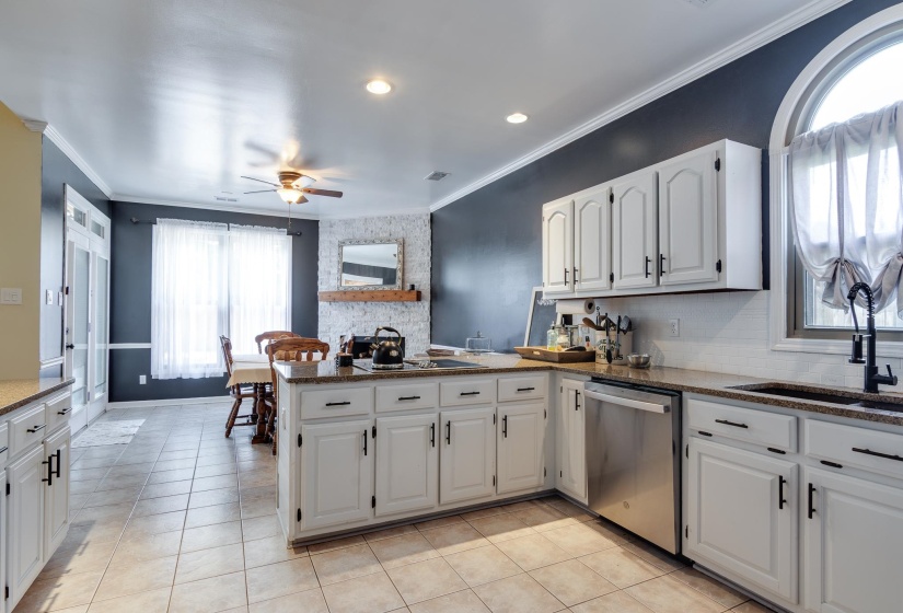 Kitchen with white cabinetry, granite countertops, and stainless steel appliances