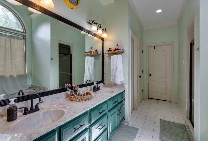 Double vanity with undermount sinks, stone countertop, and dark cabinetry