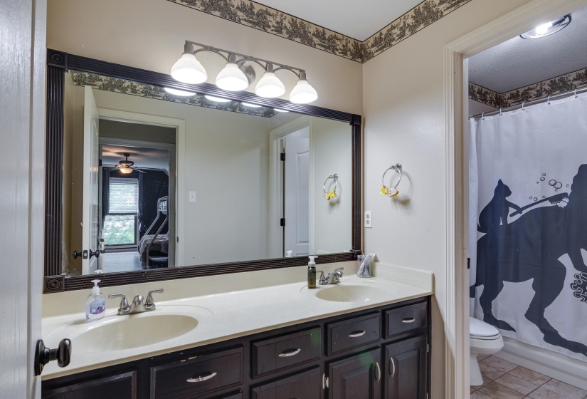 Dual vanity with integrated sinks, dark wood-finish cabinetry, and brushed nickel hardware