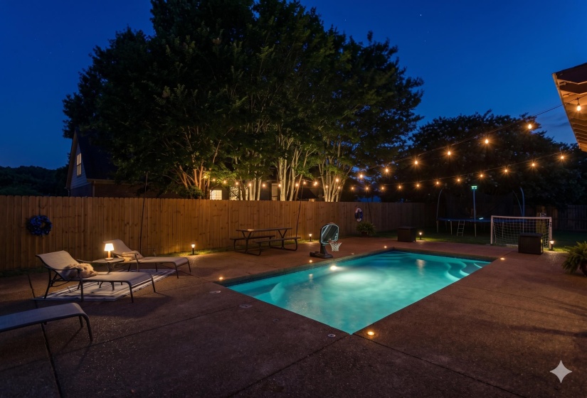 In-ground swimming pool with integrated lighting, surrounded by a concrete patio