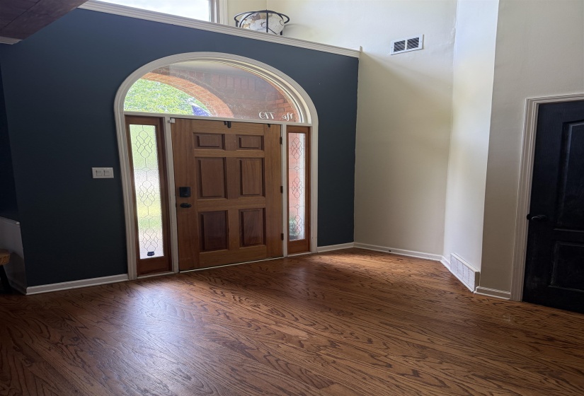 Hardwood flooring entry with an arched transom window
