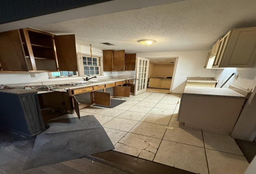 Kitchen featuring wood cabinetry, a window overlooking the exterior, and tile flooring