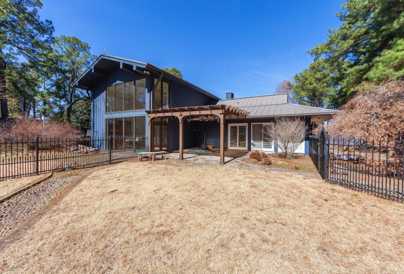 View of rear of house with a patio area, fence, metal roof, and a pergola
