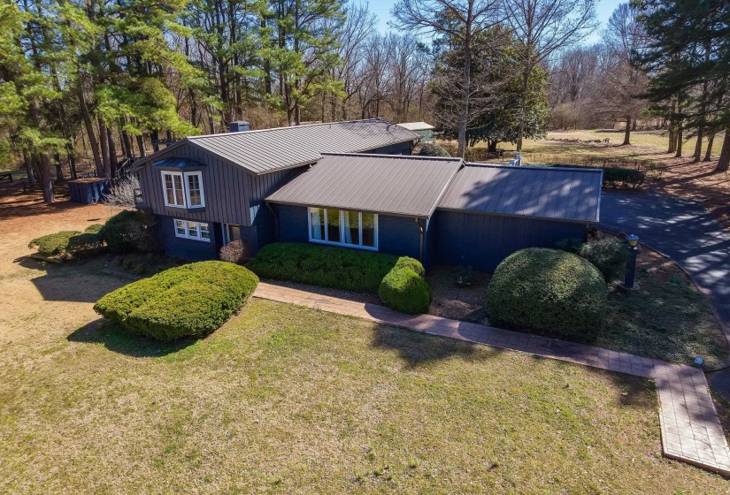 Split level home featuring metal roof and a front yard