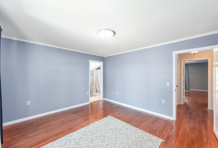 Unfurnished room with ornamental molding, baseboards, and wood finished floors