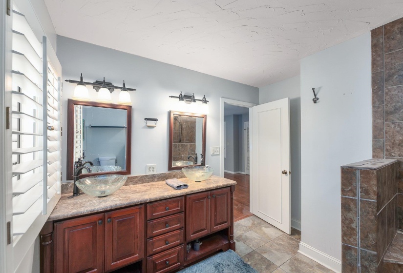 Bathroom featuring double vanity, a sink, and baseboards