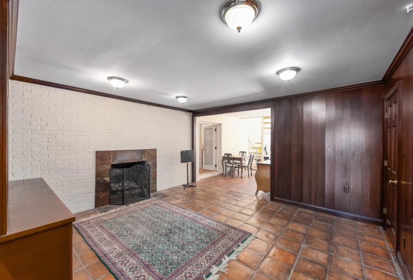 Living area with ornamental molding, a fireplace, and brick wall
