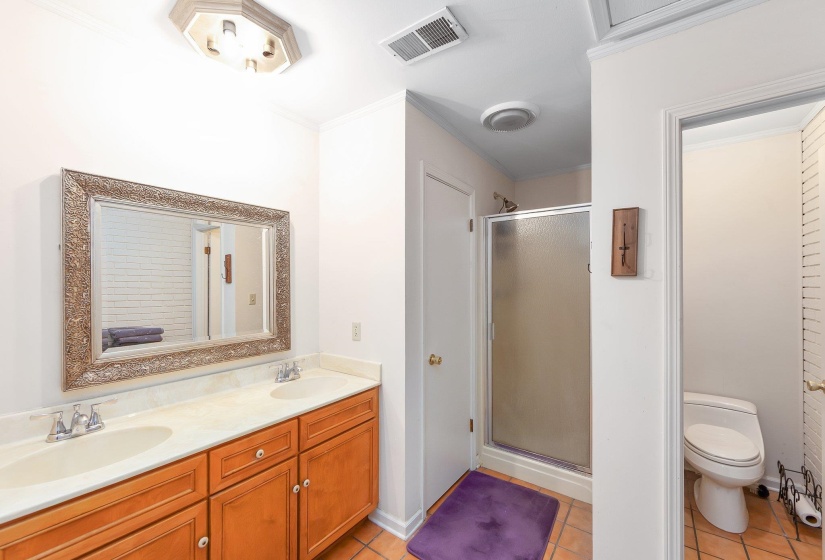 Bathroom featuring tile patterned flooring, visible vents, a sink, and a shower stall
