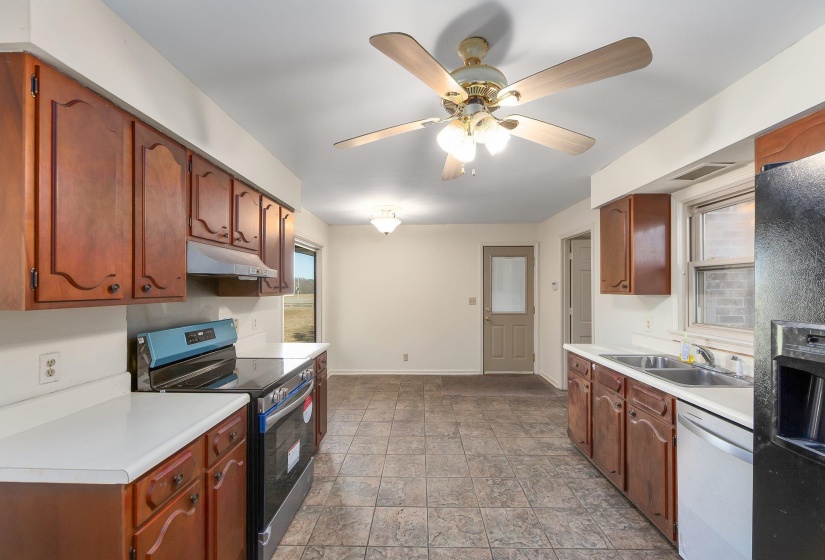 Kitchen with visible vents, light countertops, appliances with stainless steel finishes, a sink, and under cabinet range hood