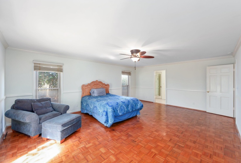 Bedroom featuring ornamental molding, multiple windows, baseboards, and a ceiling fan