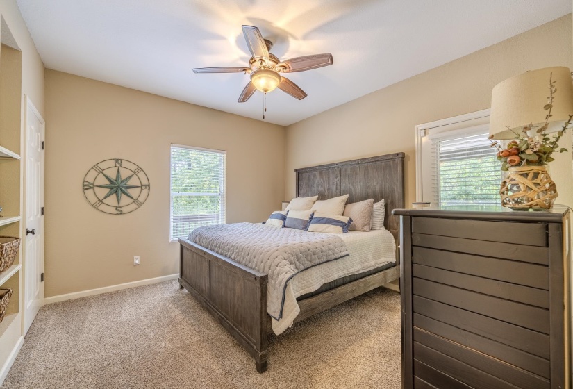 Carpeted bedroom with a vaulted ceiling and ceiling fan