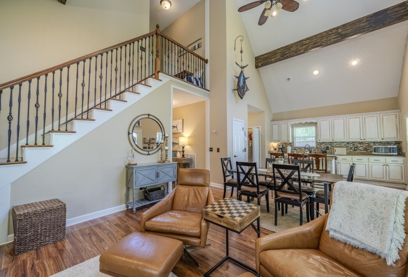 Open-concept living area with vaulted ceilings and wood-finish flooring