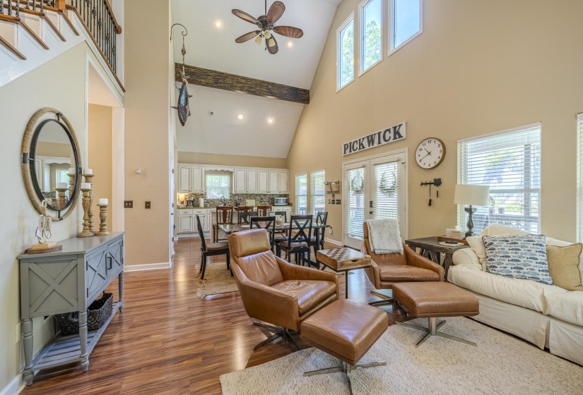 Open-concept living area featuring a vaulted ceiling with a wood-finish beam, wood-finish flooring, recessed lighting, and a ceiling fan