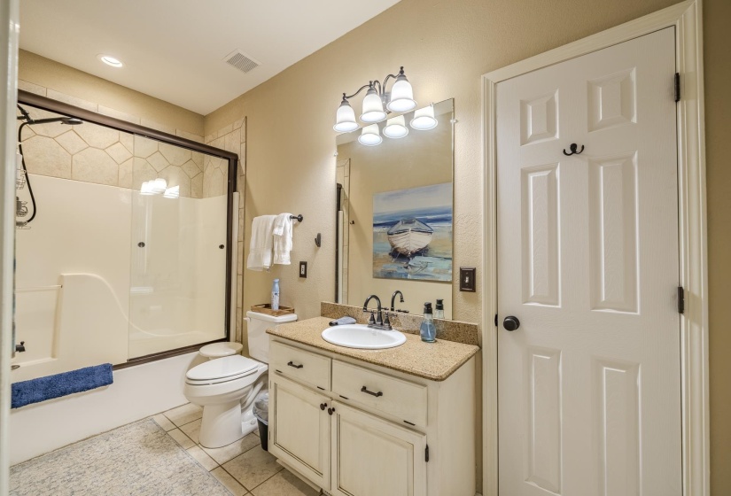 Bathroom featuring a light-toned vanity with a granite-look countertop, an integrated sink, and an overhead light fixture