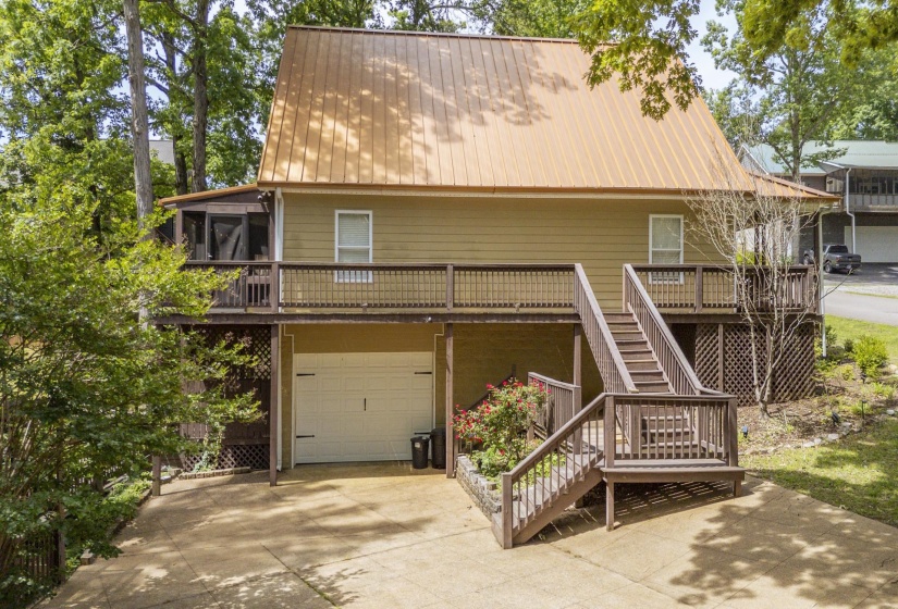 Rear exterior with a metal roof, two-car garage, and upper-level deck
