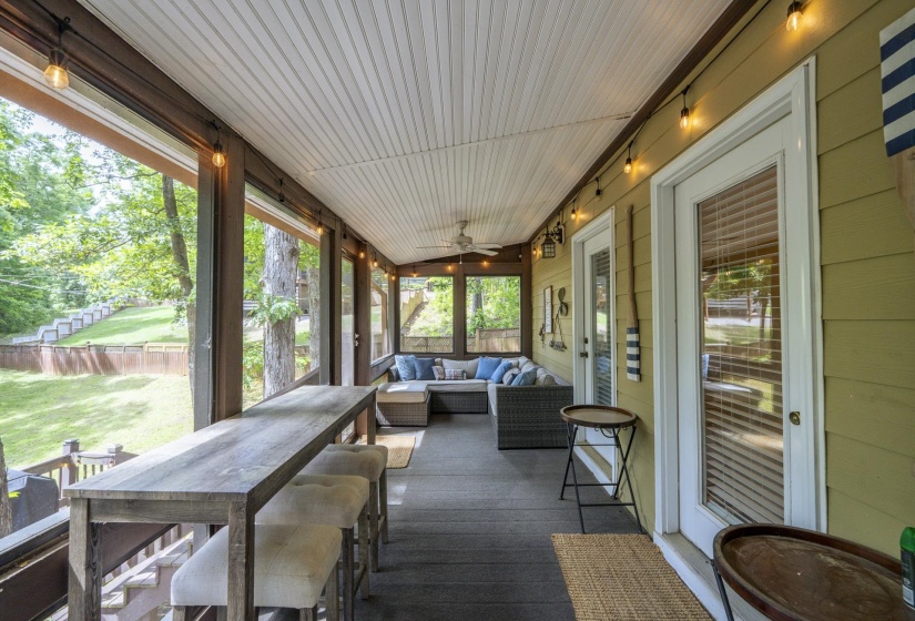 Screened porch featuring a beadboard ceiling, overhead string lighting, and direct access doors