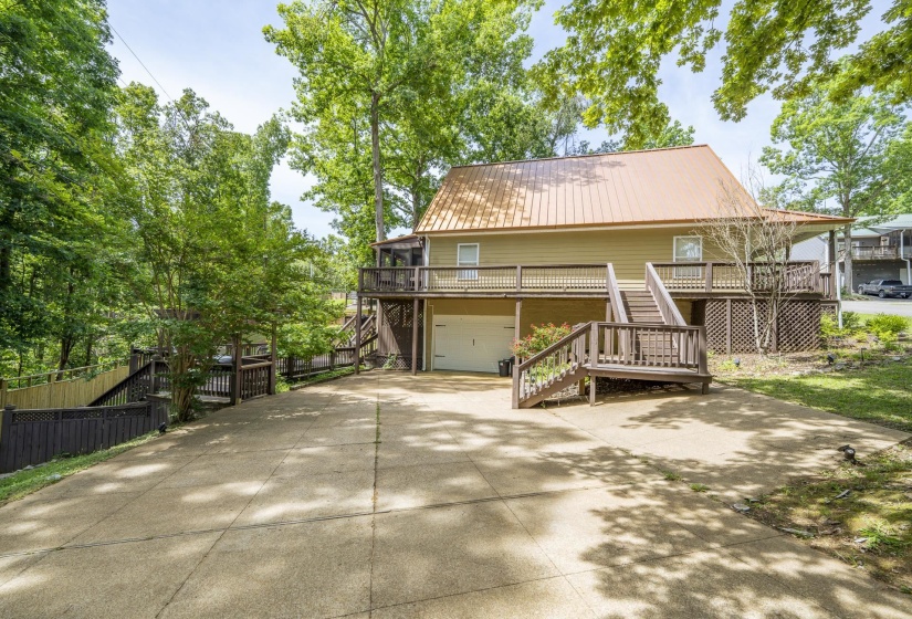 Exterior featuring a metal roof, extended decking, and an integrated garage