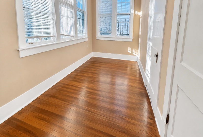 Hardwood flooring featuring a rich finish complemented by crisp white baseboards