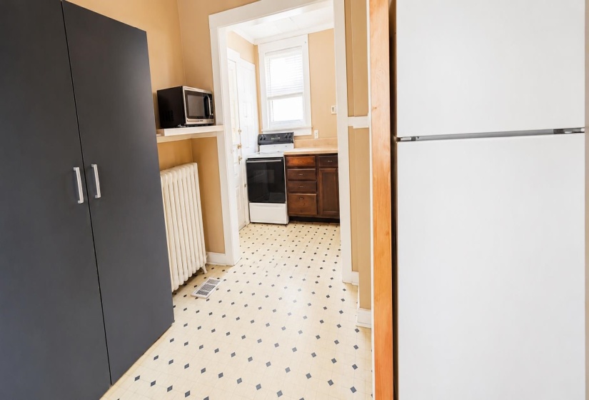 Kitchen featuring white refrigerator, dark wood-finish cabinetry, and white range