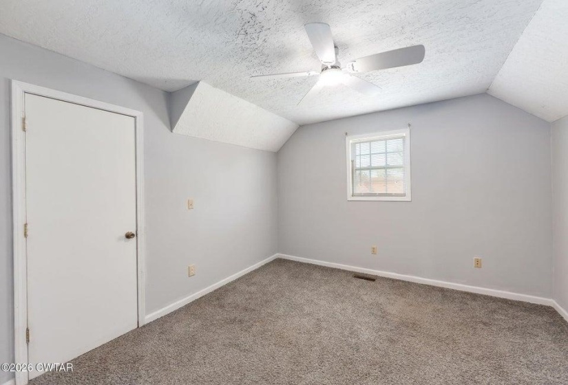 Additional living space with a textured ceiling, a ceiling fan, and carpet floors