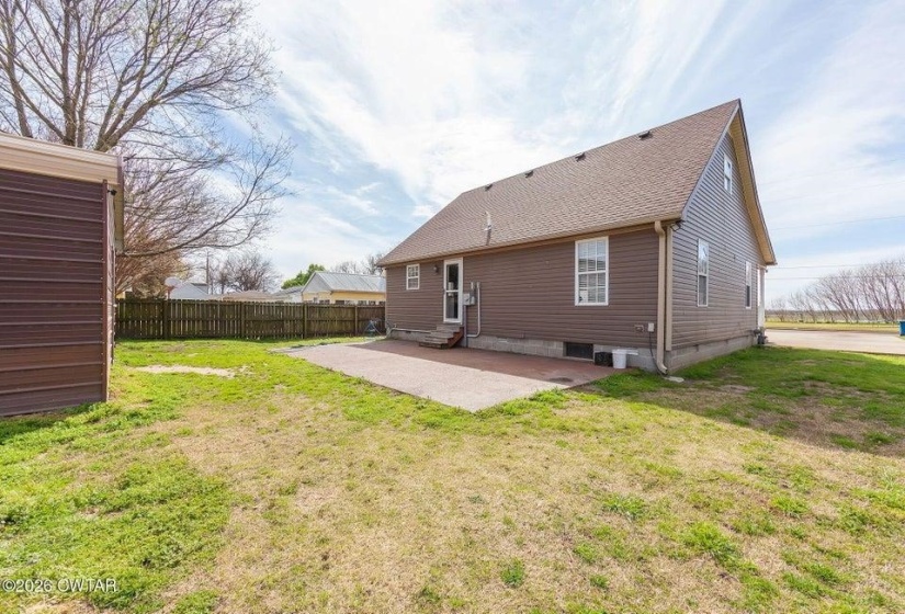 Back of property with a patio area, entry steps, and roof with shingles