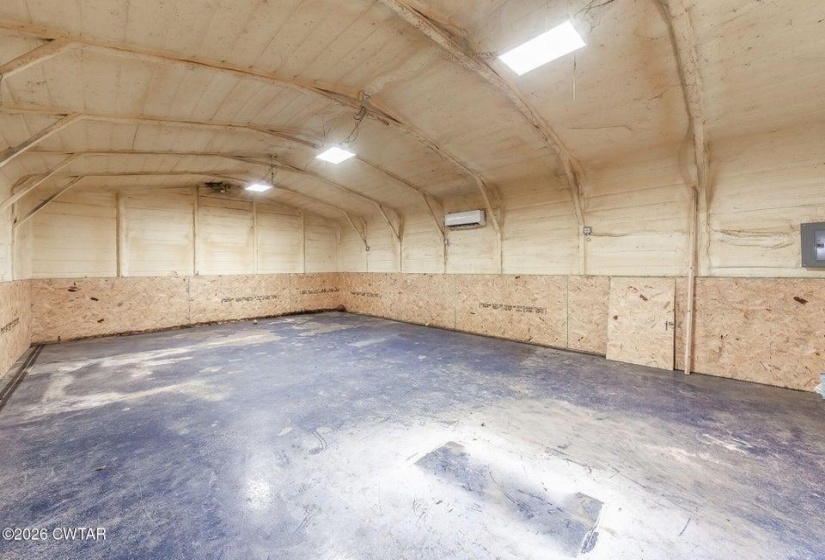 Misc room with concrete floors and vaulted ceiling