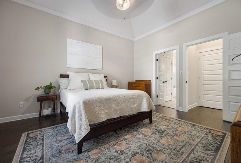 Bedroom featuring crown molding, dark wood finished floors, and a ceiling fan