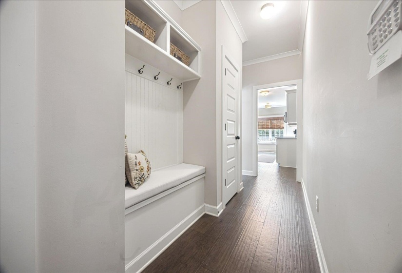 Mudroom with crown molding and dark wood-style flooring