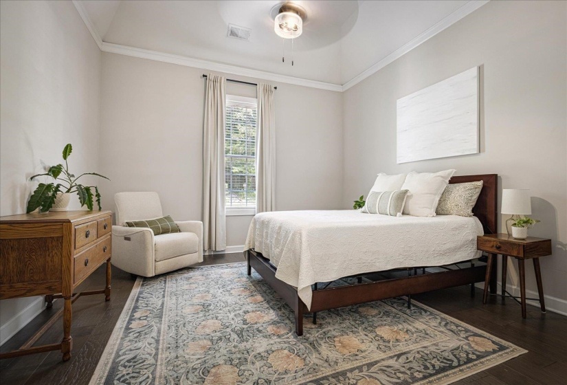 Bedroom with ornamental molding, a ceiling fan, and dark wood-style flooring