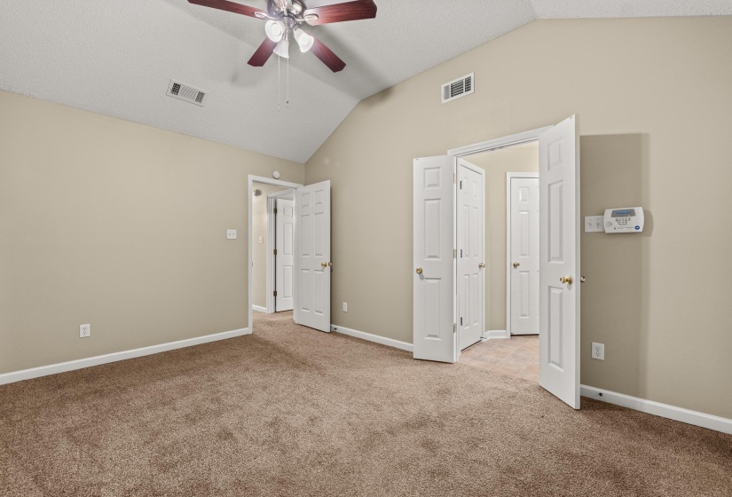 Interior room featuring a vaulted ceiling and a ceiling fan with integrated lighting