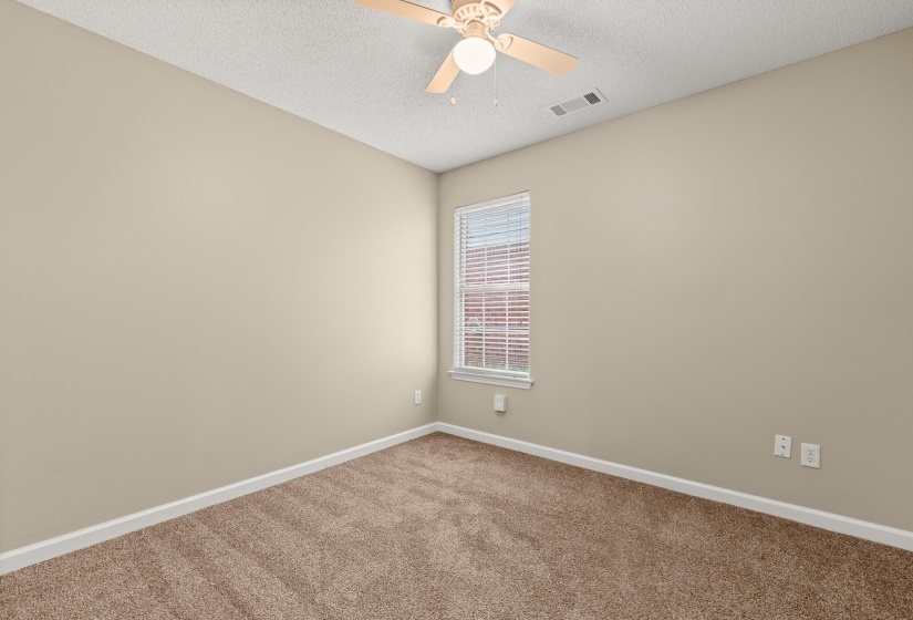 Neutral-toned walls and plush brown carpet define this room