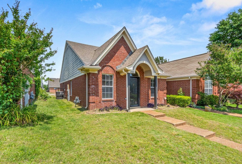 Brick exterior featuring a gabled roofline and an arched entry