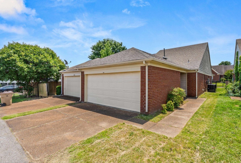 Brick exterior featuring a gabled roofline and two attached garages
