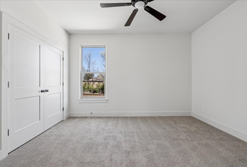 Unfurnished bedroom with light carpet, a closet, and a ceiling fan