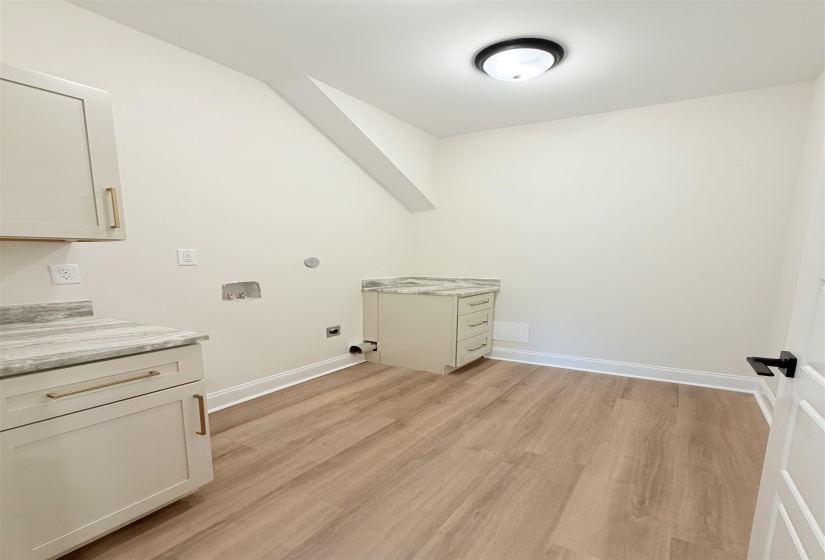 Dedicated utility space featuring wood-finish flooring