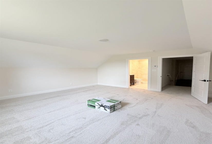 Carpeted room featuring a white paneled door with black hardware, a recessed ceiling light, and white baseboards