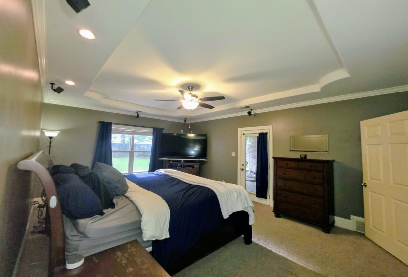 Tray ceiling with recessed lighting and a ceiling fan, featuring direct exterior access