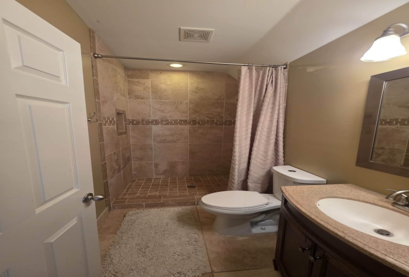 Tiled shower with decorative accent border and recessed niche