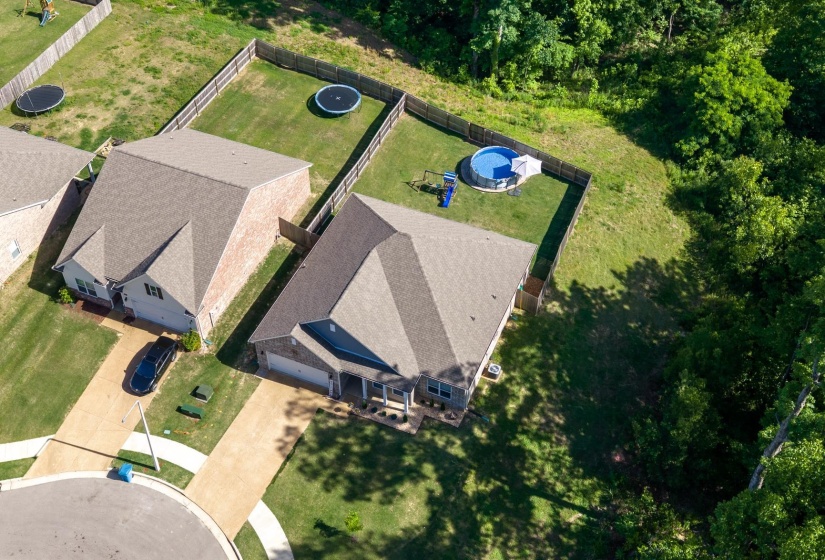 Residential property featuring a hip roof, attached garage, and a fenced backyard