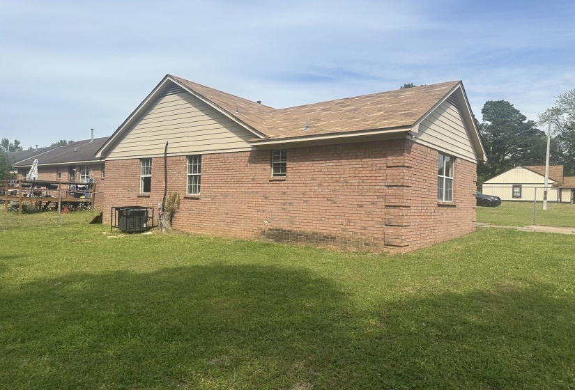 Brick exterior featuring tan horizontal siding on gables and a brown shingle roof