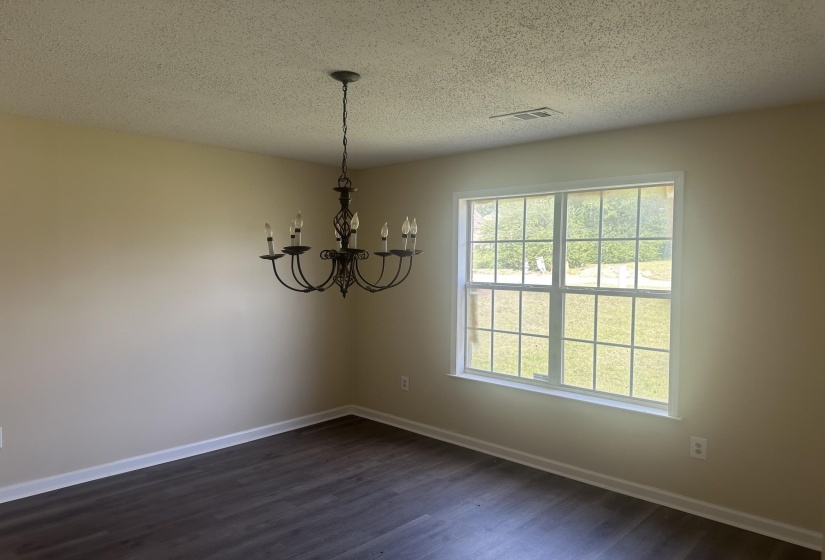 Interior space featuring dark wood-finish flooring, light neutral wall paint, and white baseboards