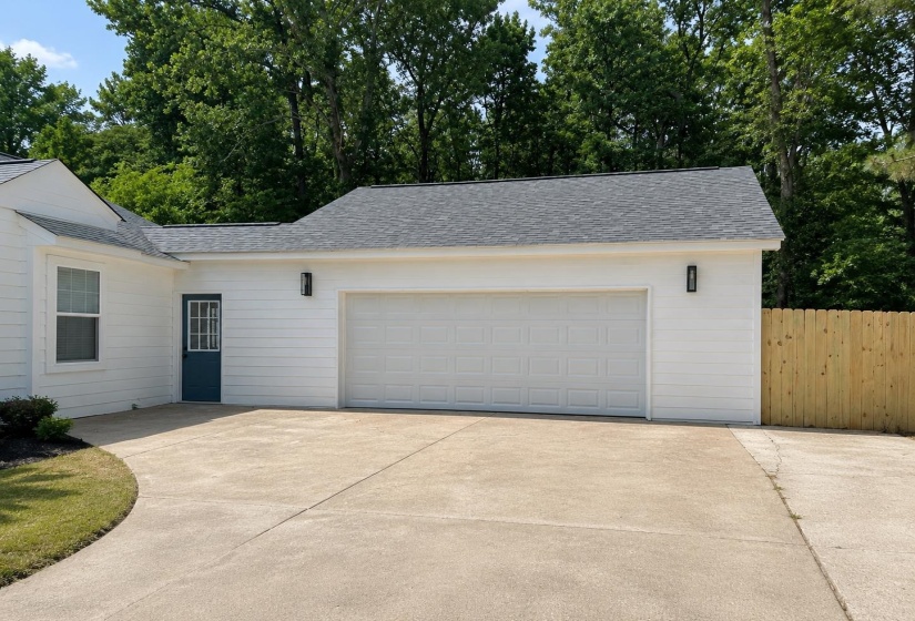 Attached two-car garage with white paneled door, complemented by a pedestrian entrance with a dark blue door and gridded window