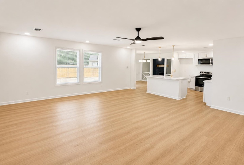 Open-concept living space featuring wood-finish flooring, recessed lighting, and a contemporary ceiling fan