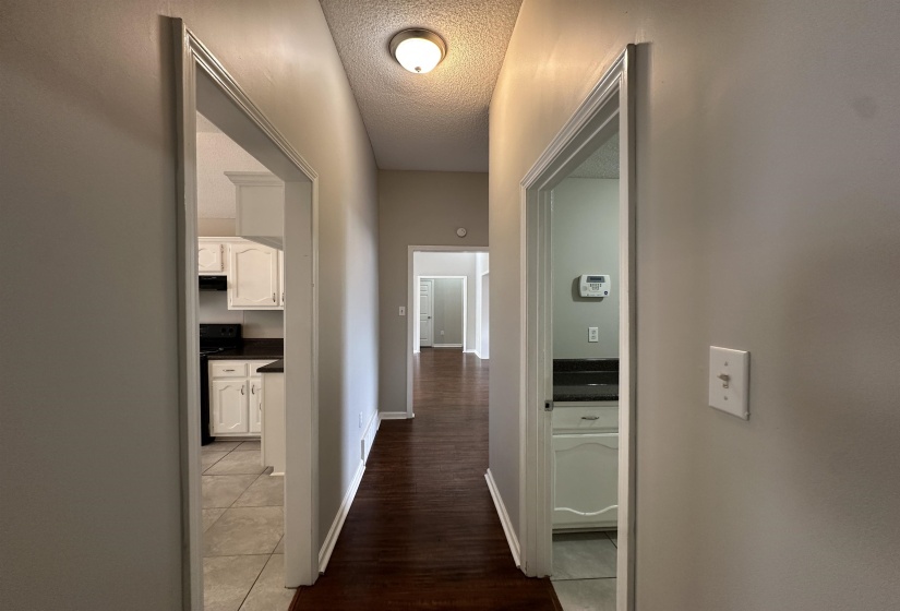 Hall featuring a textured ceiling and light tile patterned floors