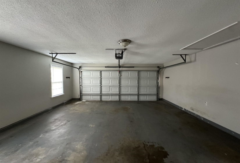 Garage with baseboards and a garage door opener