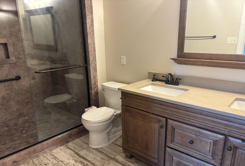 Bathroom featuring a double vanity with an integrated countertop, dark wood-finish cabinetry, and oil-rubbed bronze fixtures