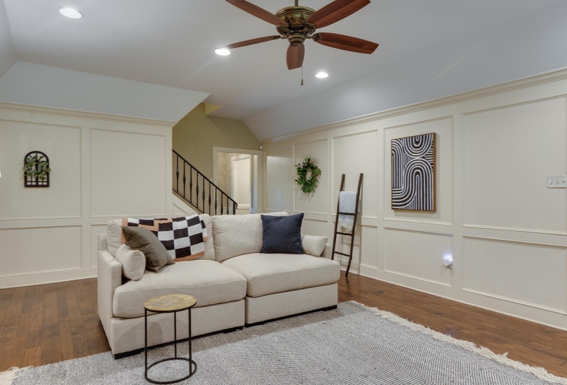 Spacious room featuring wood-finish flooring, recessed lighting, and a ceiling fan